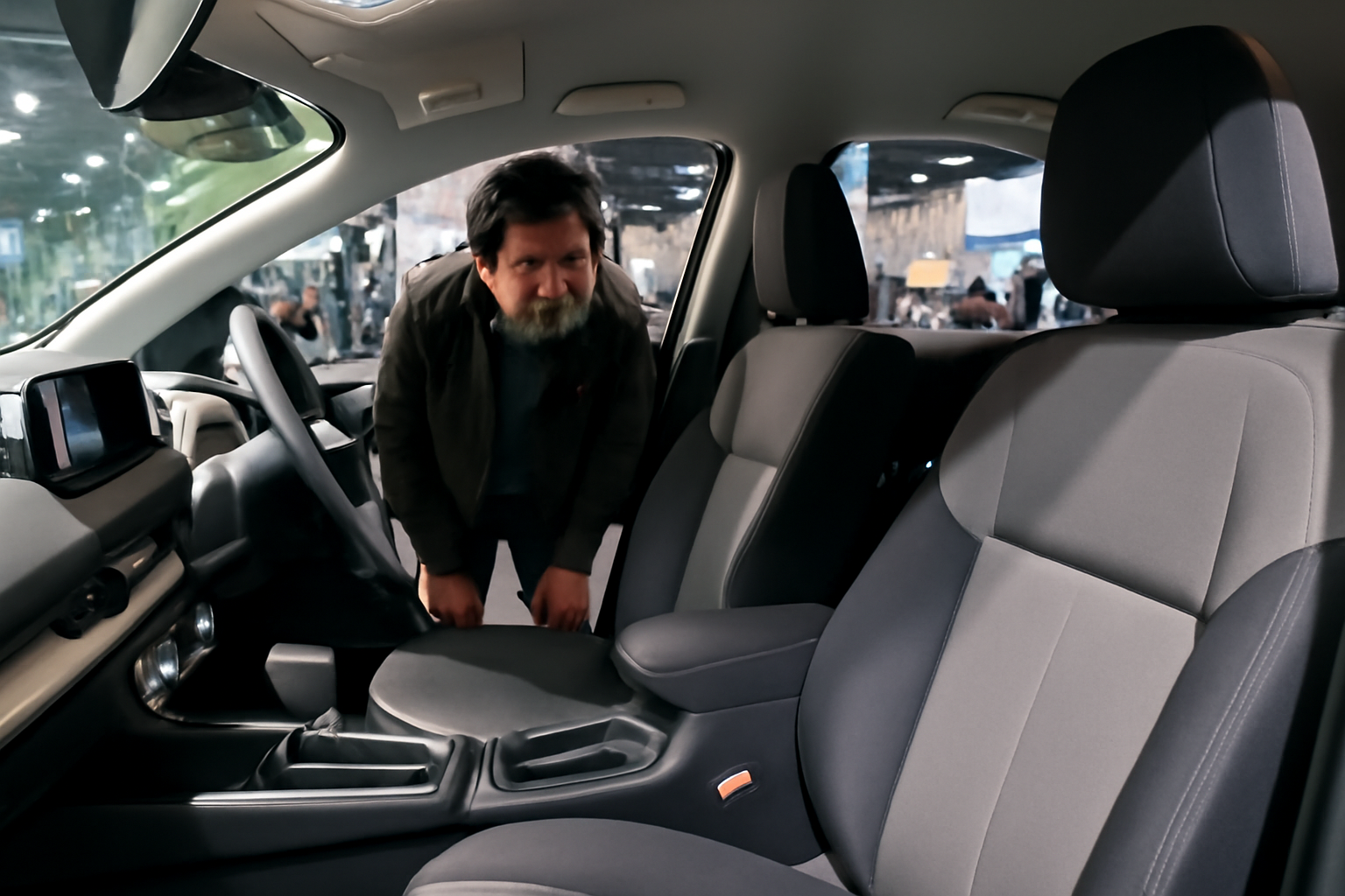 展示車両の内装を覗く来場者と車内レイアウト