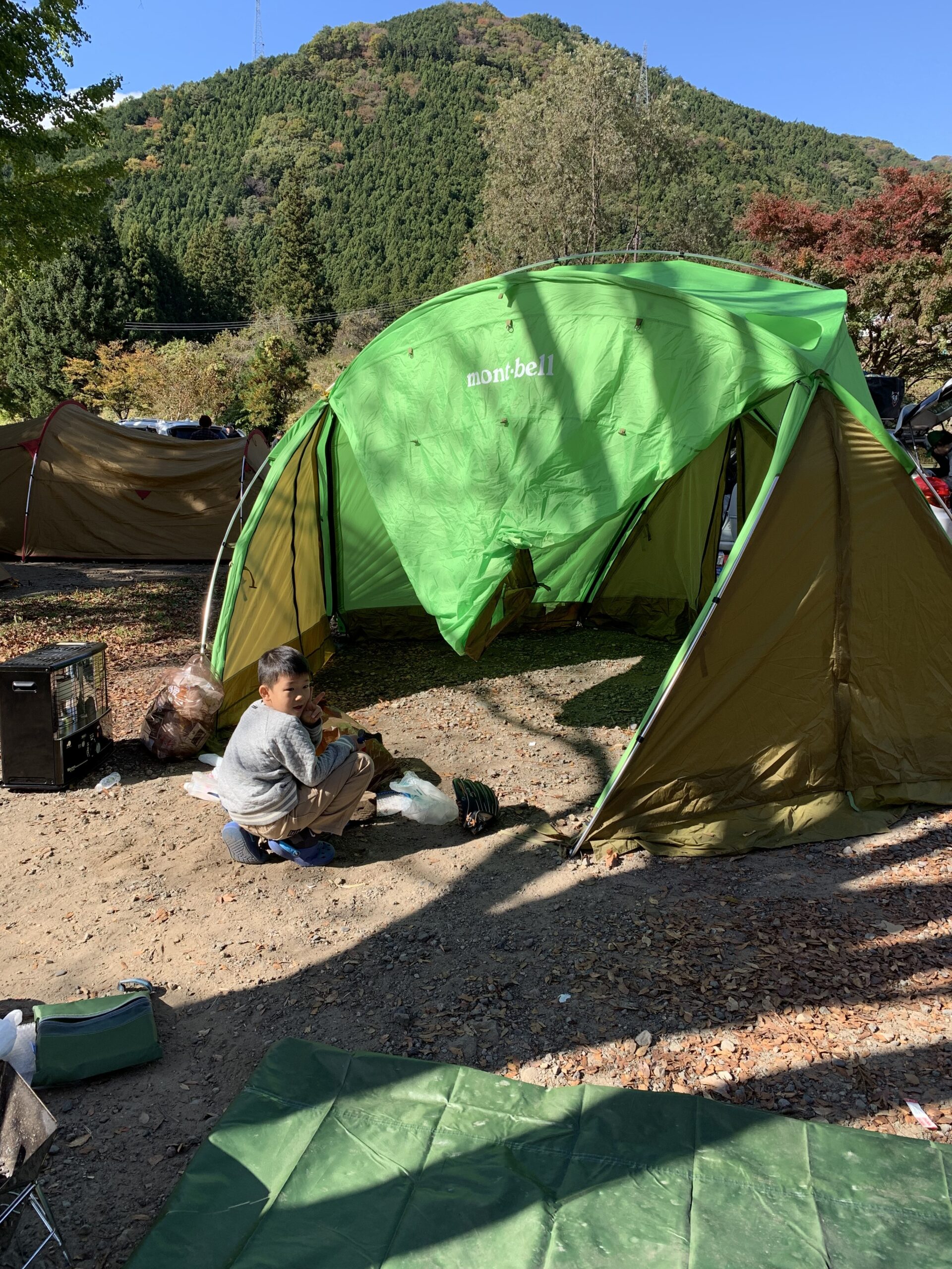 鬼怒川温泉オートキャンプ場のサイトと背後の紅葉の山
