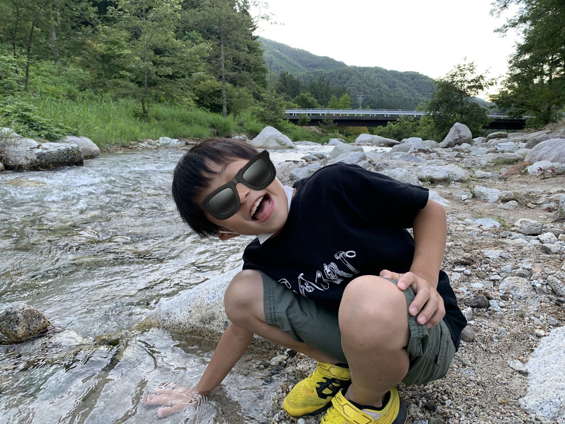 川で笑顔ではしゃぐ子ども。高原の川遊びは涼しさと夏の思い出を一気に稼げます