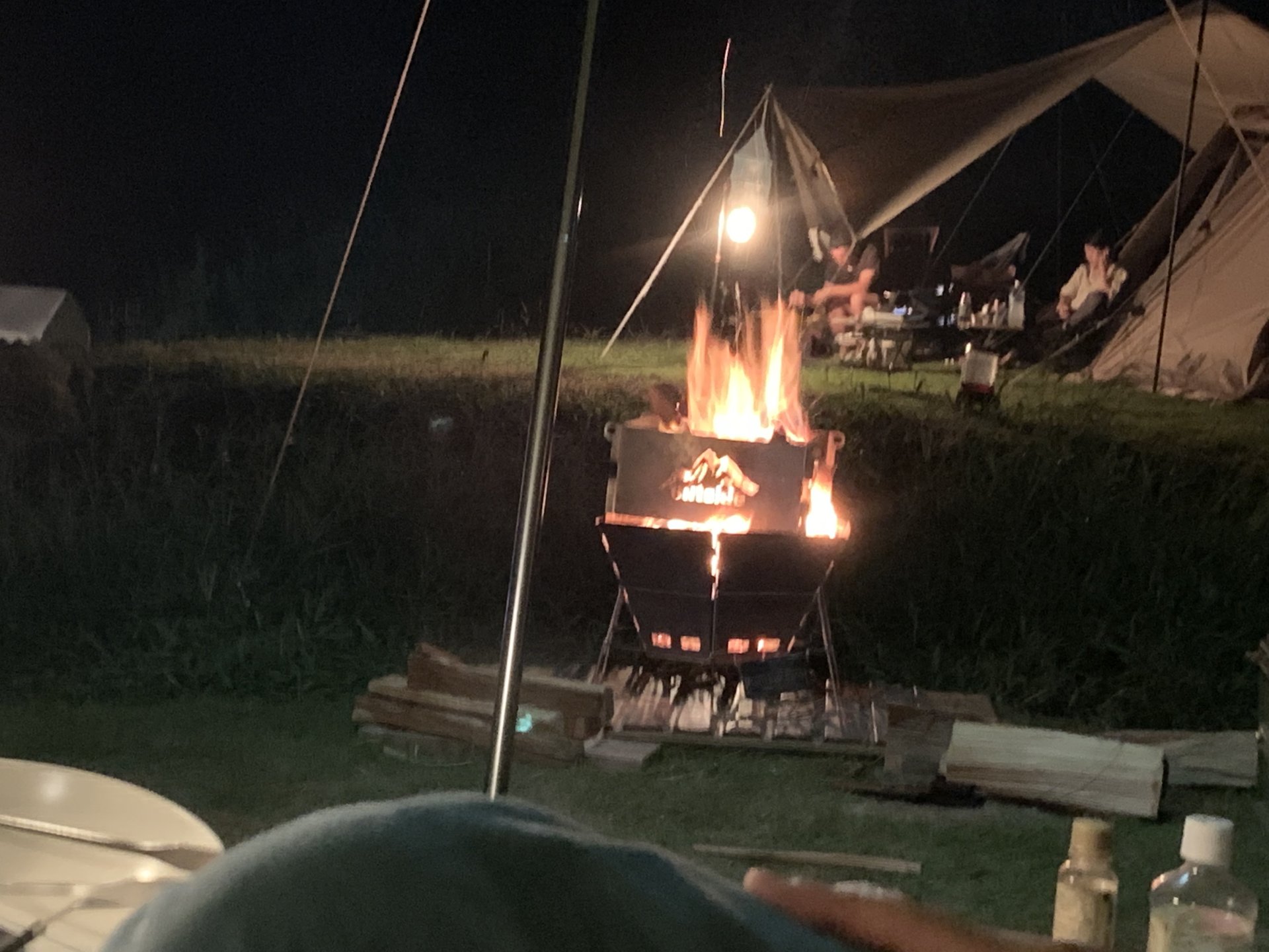 夜の焚き火。タープとランタンの灯りの下で、一日の遊び疲れがゆっくりほどけていきます