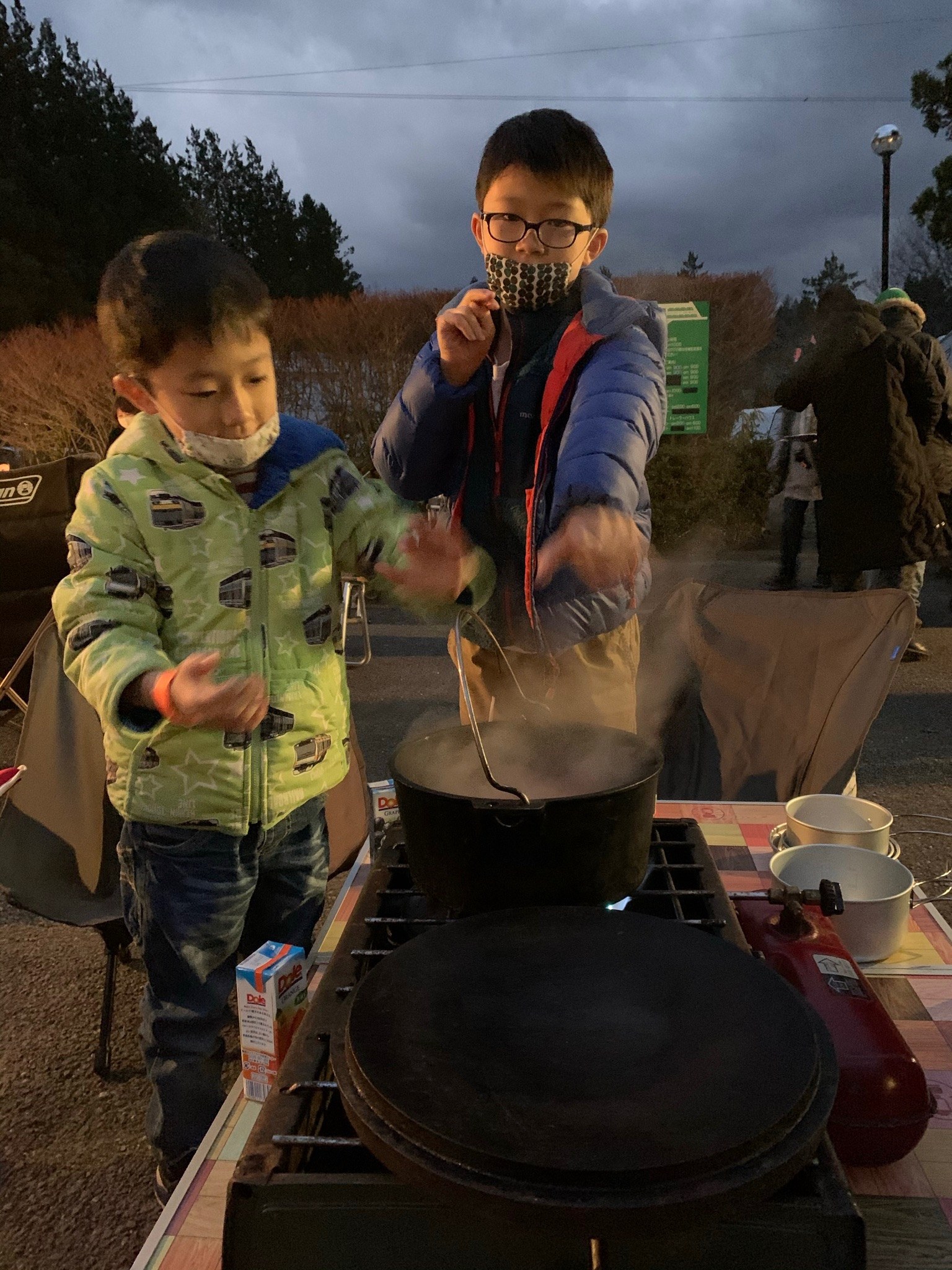 ツーバーナーとダッチオーブンでスープを作る子どもたち